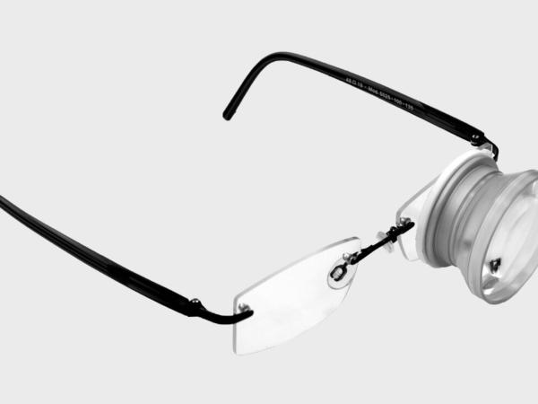 Brille mit eingebautem Fernrohr auf dem linken Glas
